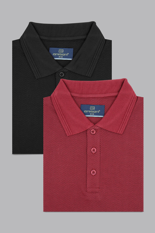 Two folded polo shirts, one black and one red, with a brand label on a gray background.