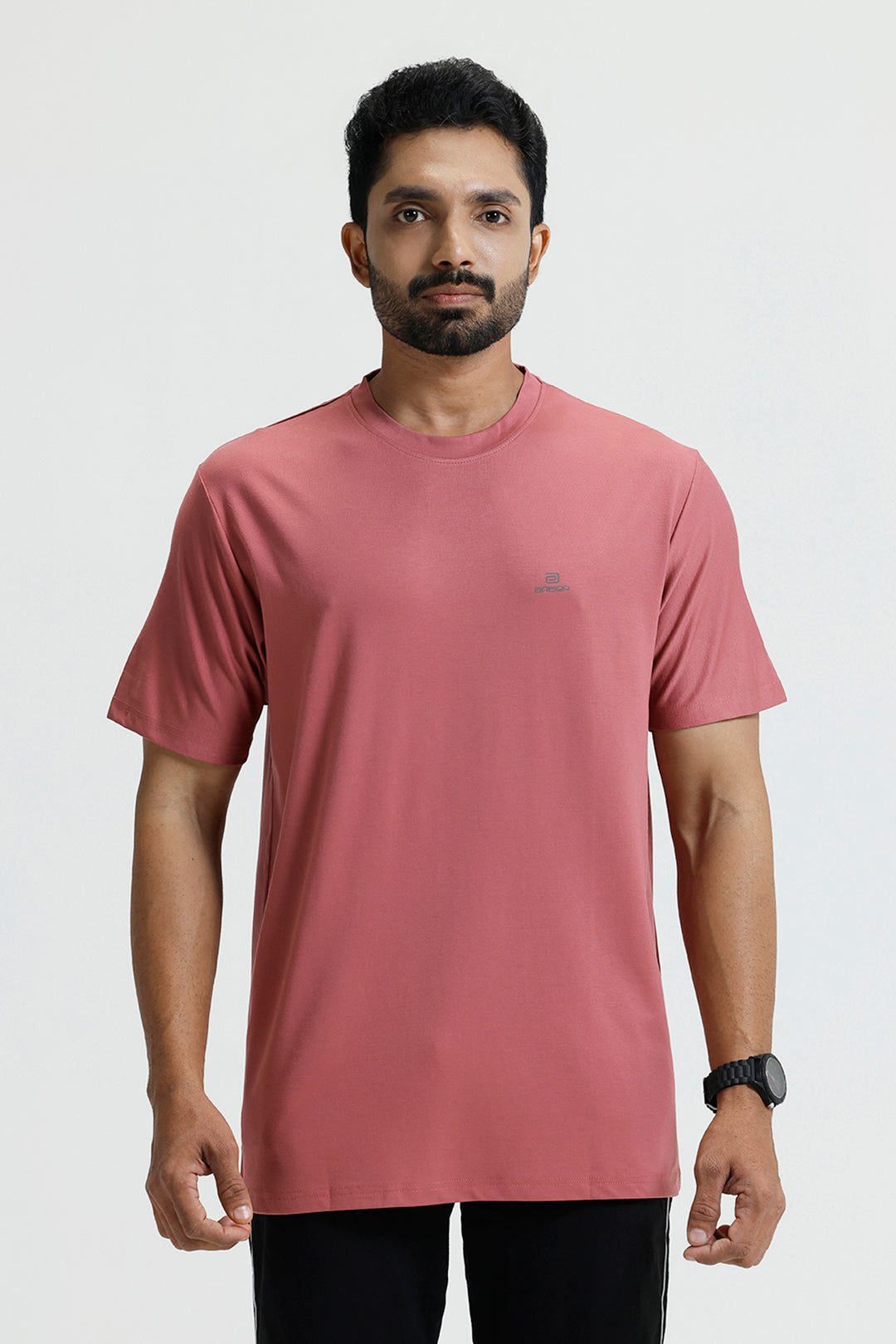 Man wearing a red t-shirt with a logo on a white background