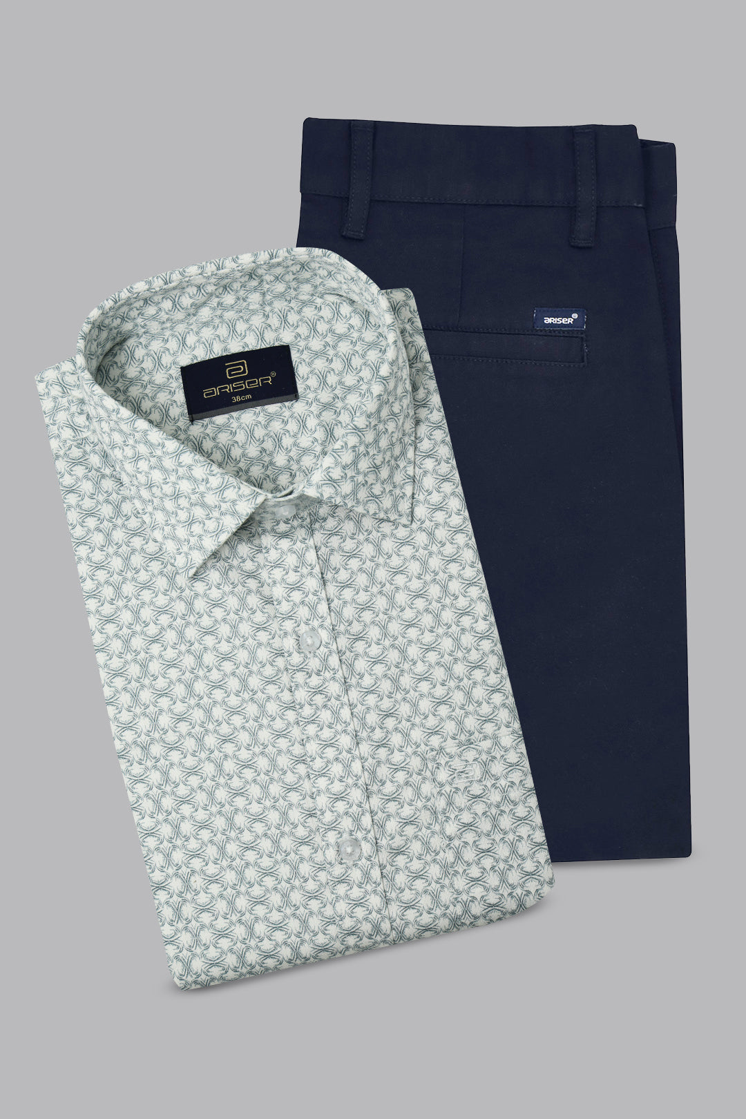 Folded patterned shirt and navy pants on a gray background
