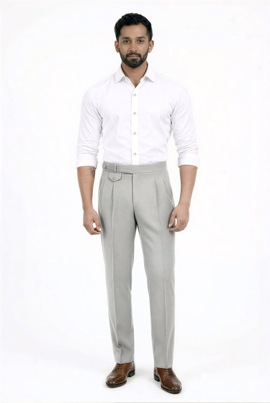 Man wearing a white shirt and gray pants on a white background