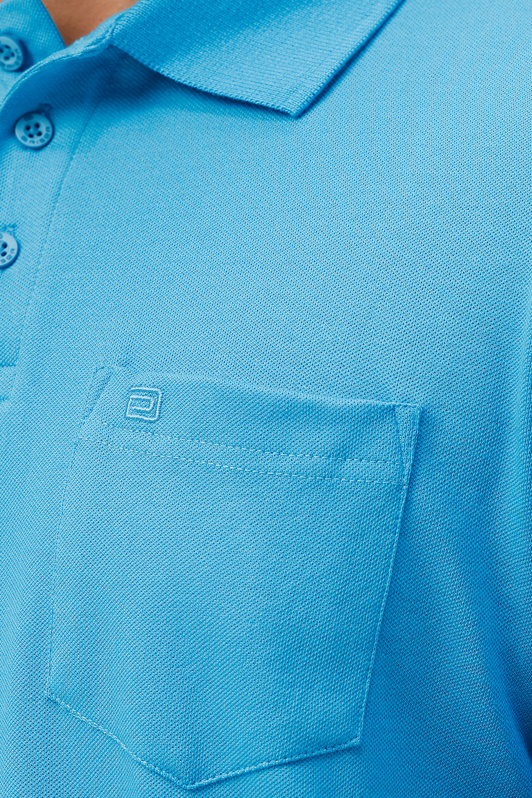 Close-up of a blue polo shirt with a pocket.